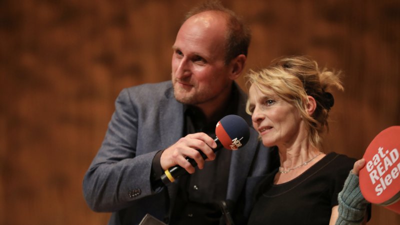 Daniel hält Katharina ein Mikorofon hin.