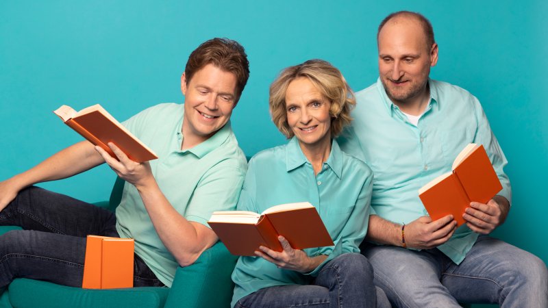 Jan, Katharina und Daniel sitzen mit aufgeschlagenen Büchern nebeneinander.