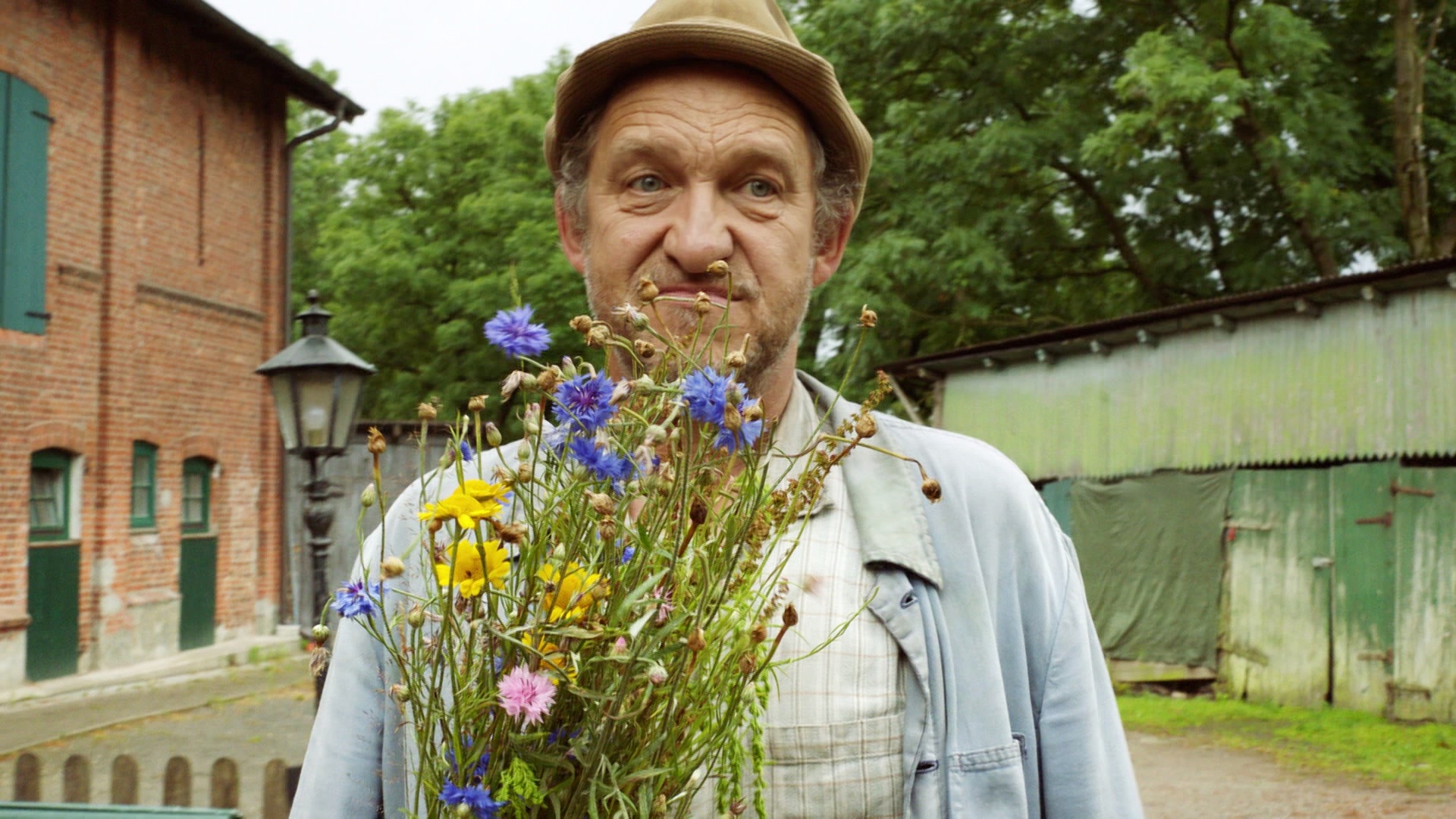 Adsche hält einen Blumenstrauß in der Hand.