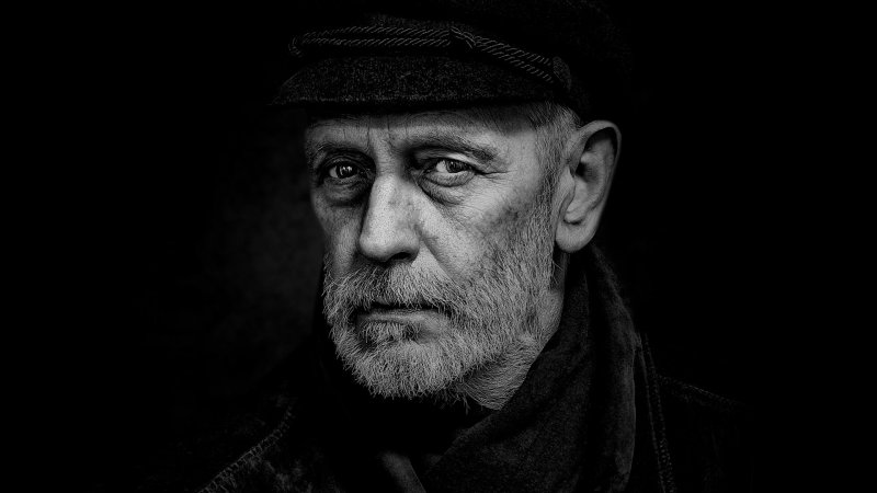 Porträt eines Mannes mit Bart und Mütze.