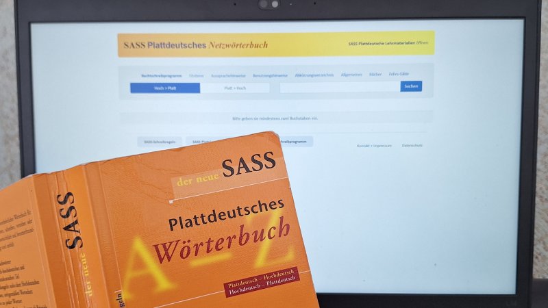 Das plattdeutsche Wörterbuch "Sass" vor der Website mit dem Online-Wörterbuch