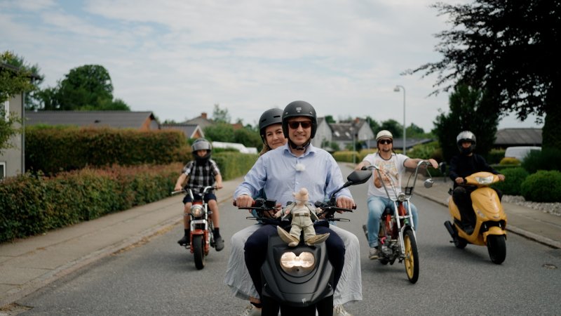 Simone Mischke und Anders Køpke Christensen fahren mit einem Motorroller.