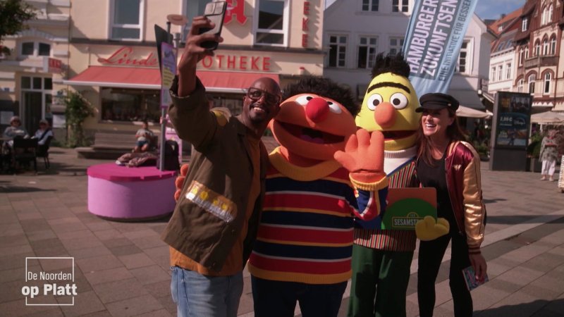 Annie Heger und Yared Dibaba lächeln mit Ernie und Bert in die Kamera.