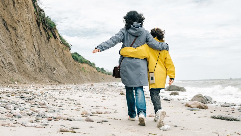 Eine Frau und ein Kind am Strand.