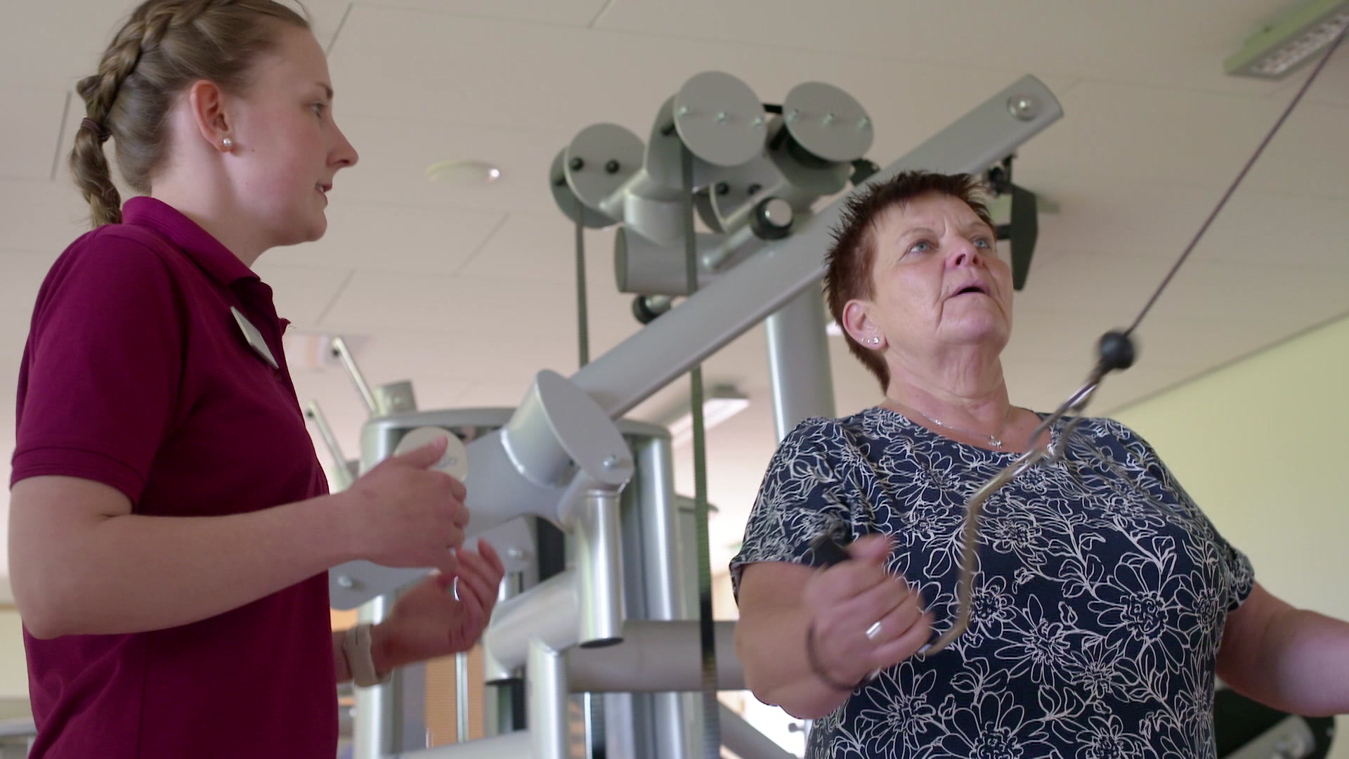 Die Patientin trainiert unter Anleitung an einem Trainingsgerät