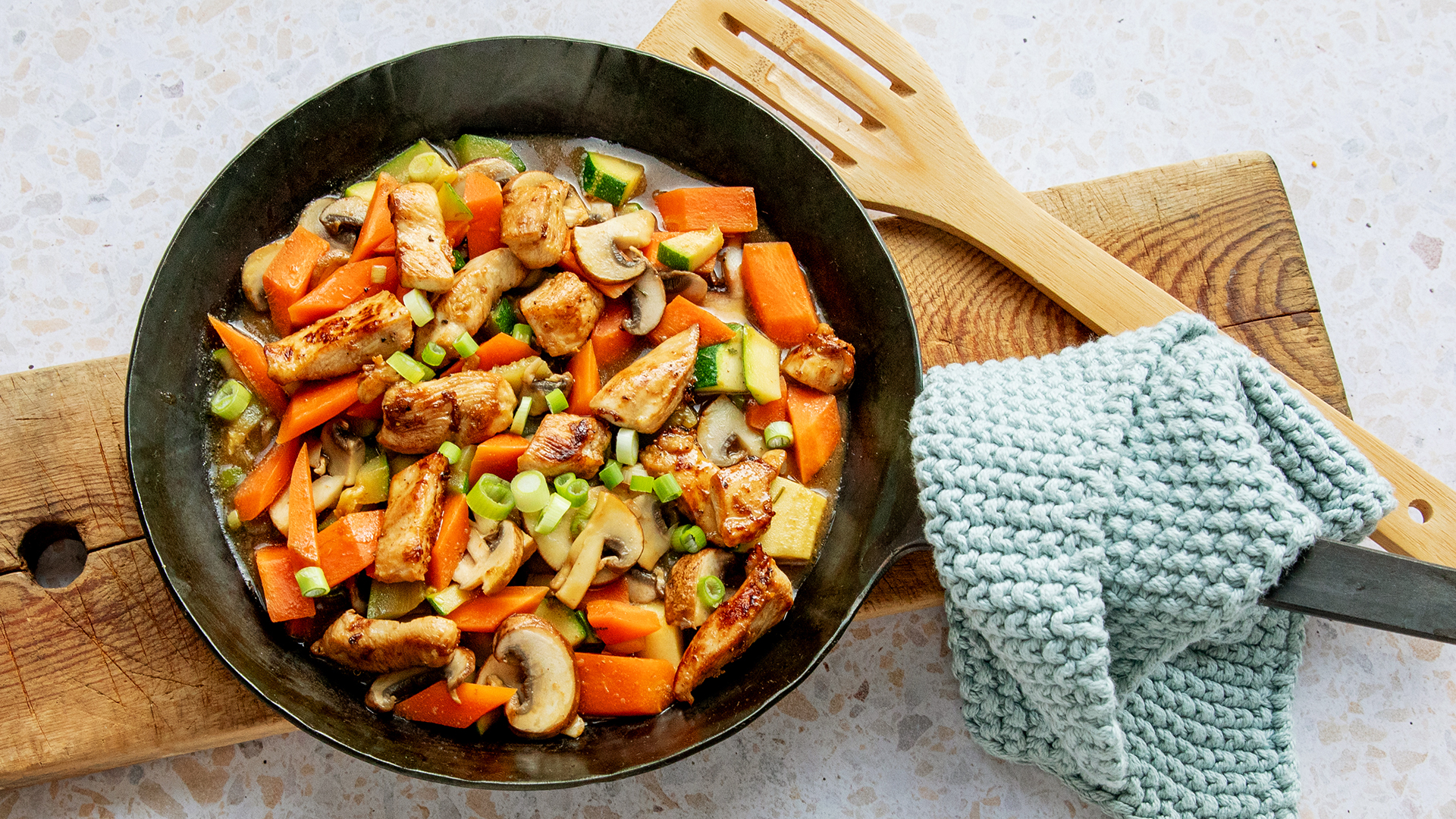 Eine Pfanne mit gebratenem Hähnchen und Gemüse.