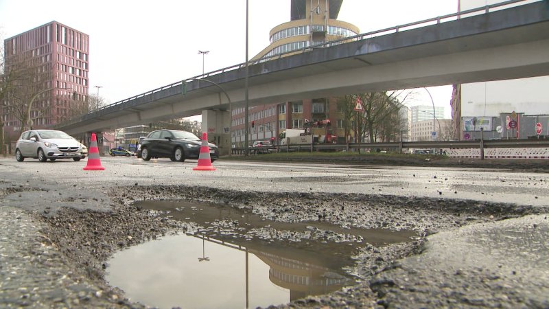 Schlaglöcher nach dem Winter auf einer Straße in Hamburg.