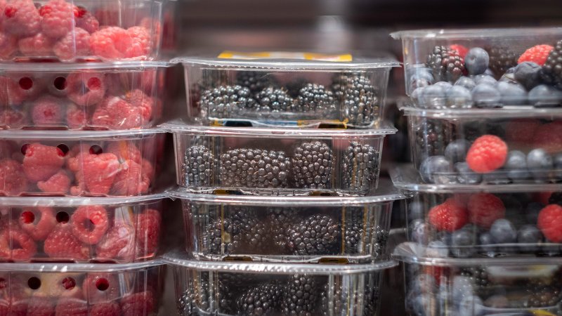 Verschiedene Beeren in Kunststoffverpackungen abgepackt im Kühlregal.