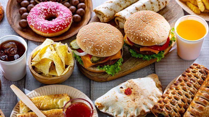 Zwei Hamburger, Tortilla-Chips, Donut, Gebäck, Frühlingsrollen, Fladenbrot, Blätterteigrollen und Softdrinks