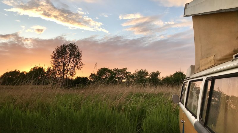 Ein VW-Bus Camper bei Sonnenuntergang.